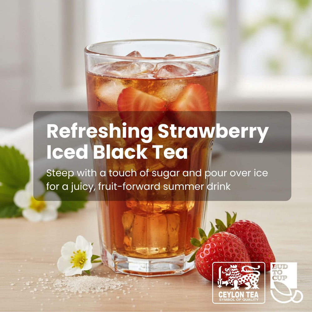 Glass of strawberry iced black tea with strawberries and flowers on a wooden surface, featuring Ceylon Tea branding.