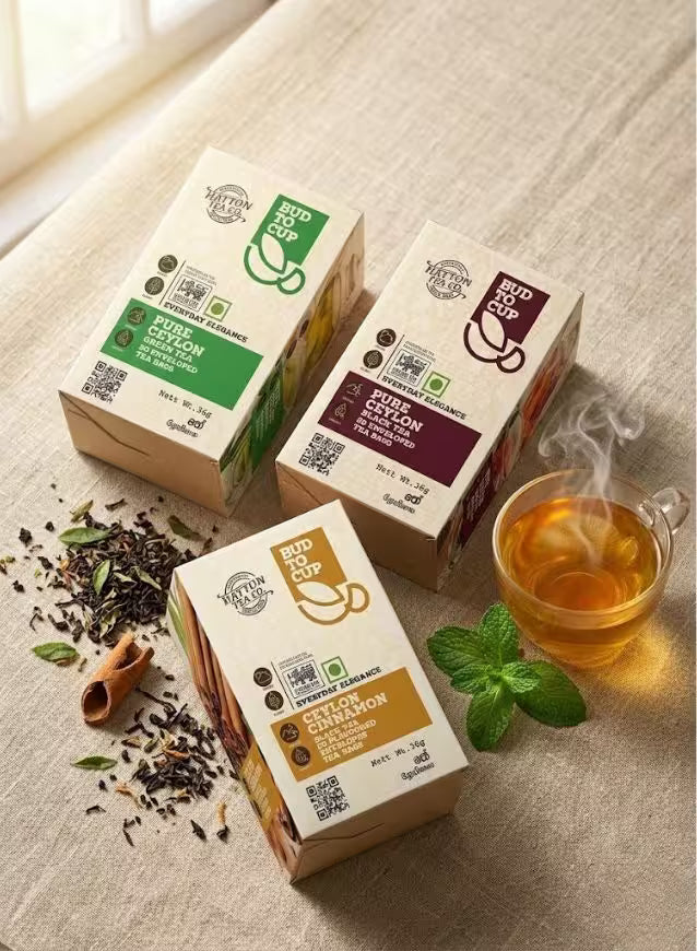 Three boxes of tea on a textured surface with a steaming cup of tea nearby.