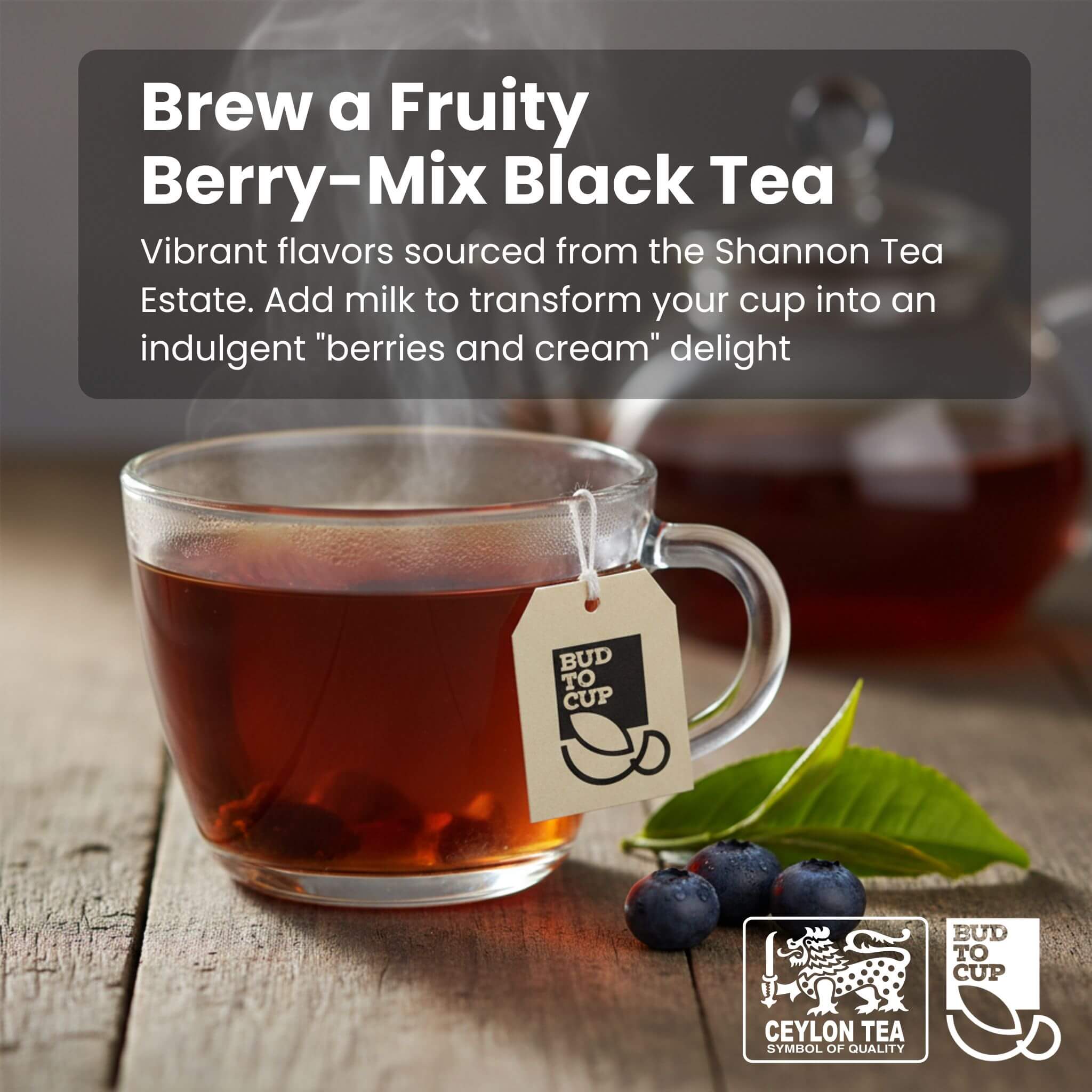 Glass mug of fruity berry-mix black tea with tea leaves and berries on a wooden surface, featuring 'Bud to Cup' branding.
