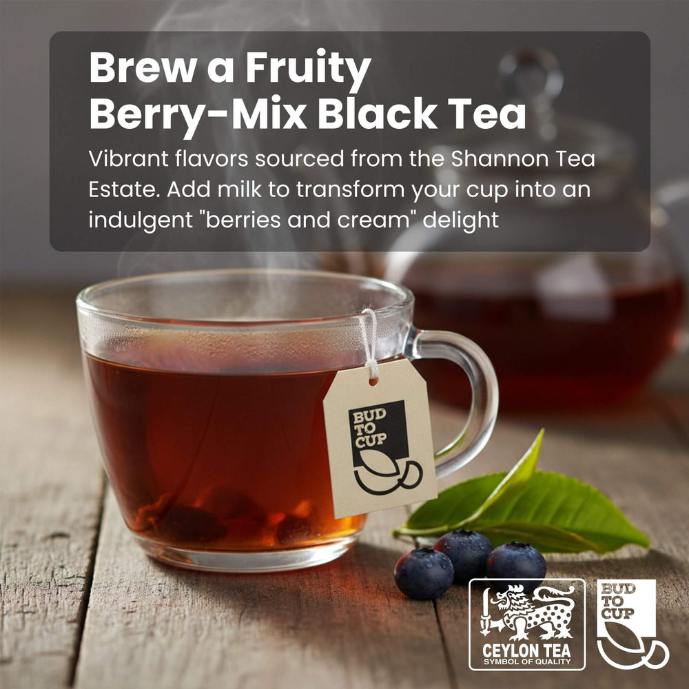 Glass mug of fruity berry-mix black tea with tea leaves and berries on a wooden surface, featuring 'Bud to Cup' branding.