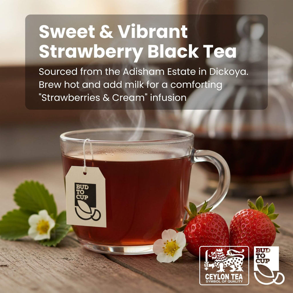 Glass mug of strawberry black tea with a teabag, strawberries, and flowers on a wooden surface.